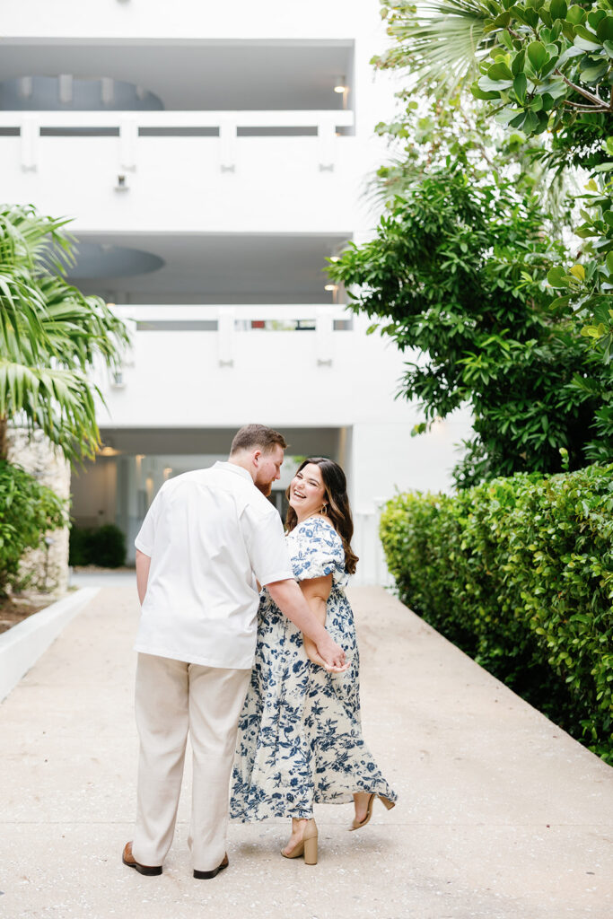 Claire looks back at Reece with a joyful smile as they walk hand in hand at their engagement session in Key Largo, photographed by Claudia Amalia Photography.