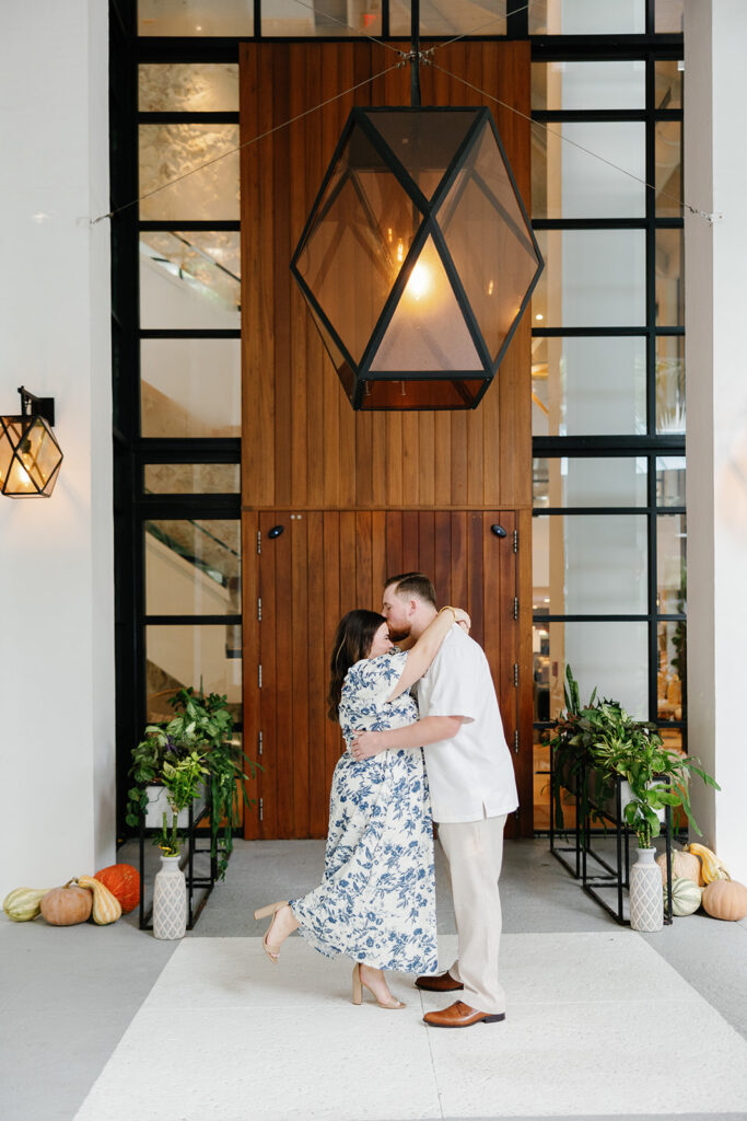 Claire and Reece embrace in front of the elegant wooden doors at Bakers Cay Resort, captured by a Key Largo wedding photographer.