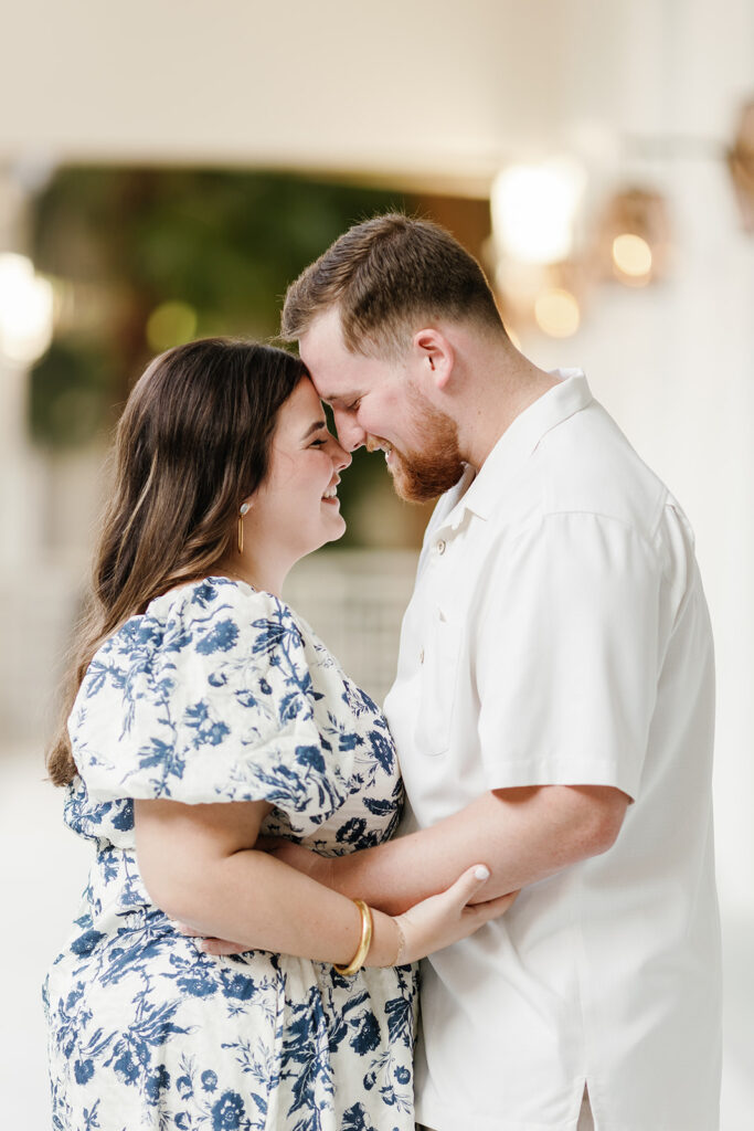 Claire and Reece smile as they lean in forehead to forehead, radiating joy during their engagement shoot in Key Largo.