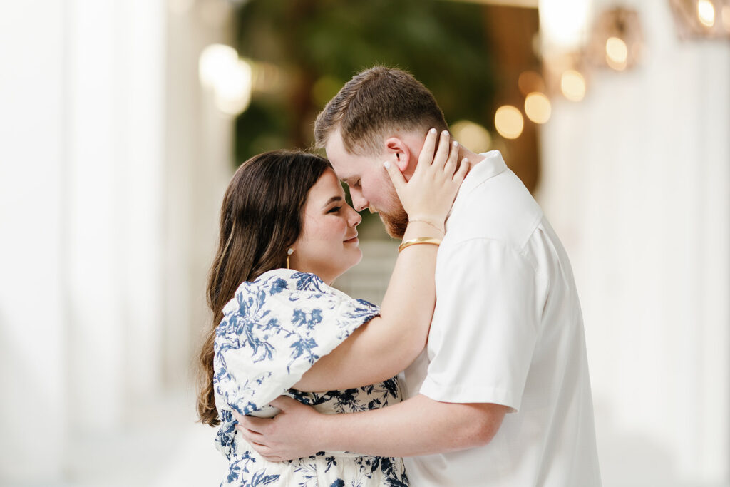 A tender moment between Claire and Reece as they embrace, beautifully framed by the warm glow of the resort's interiors—captured by the best engagement photographer.