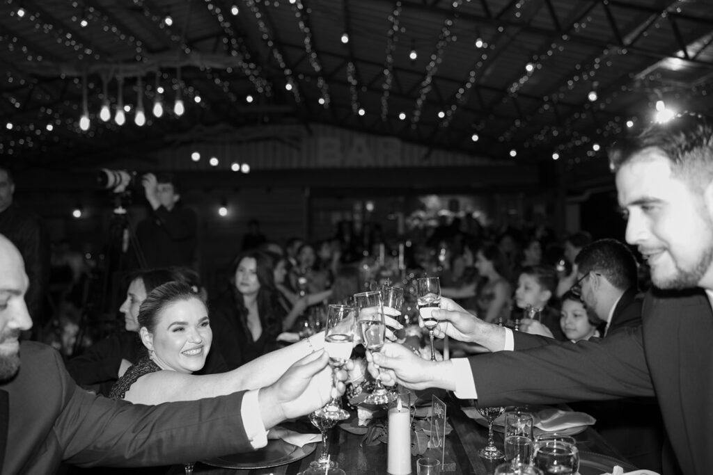 Guests raising champagne glasses in a joyful wedding toast at Jeannie and Carlos' Biltmore Hotel Coral Gables wedding.