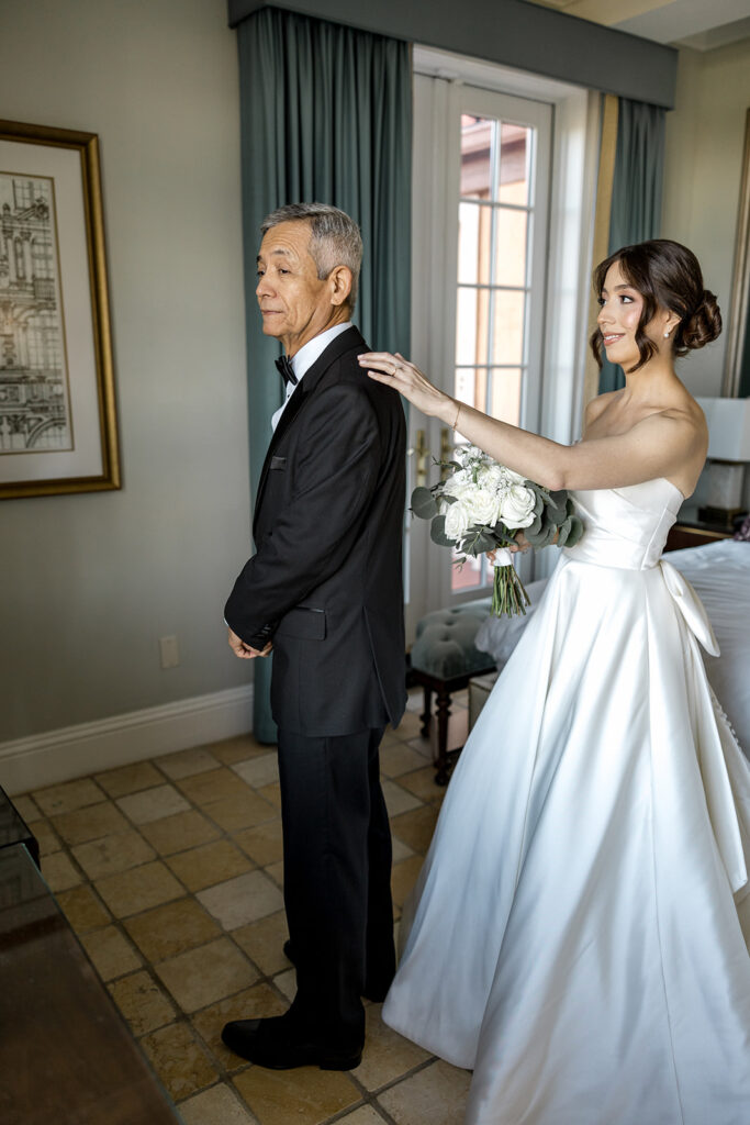 Bride Jeannie taps her father’s shoulder for a heartfelt first look at Biltmore Hotel Coral Gables.