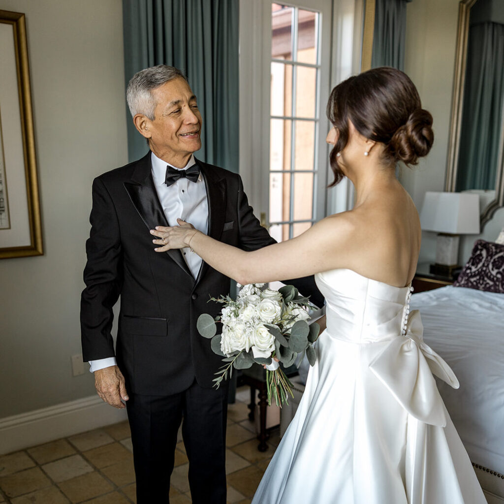 Bride Jeannie shares a loving exchange with her father before walking down the aisle at Biltmore Hotel Coral Gables.