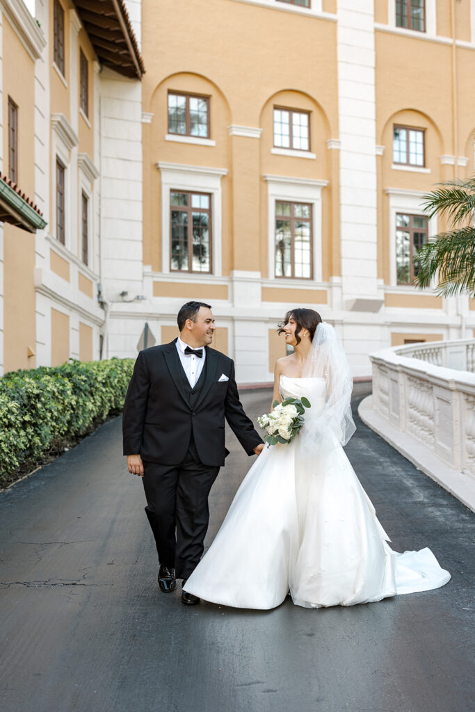 eannie and Carlos walk hand-in-hand through the historic architecture of the Biltmore Hotel Coral Gables.