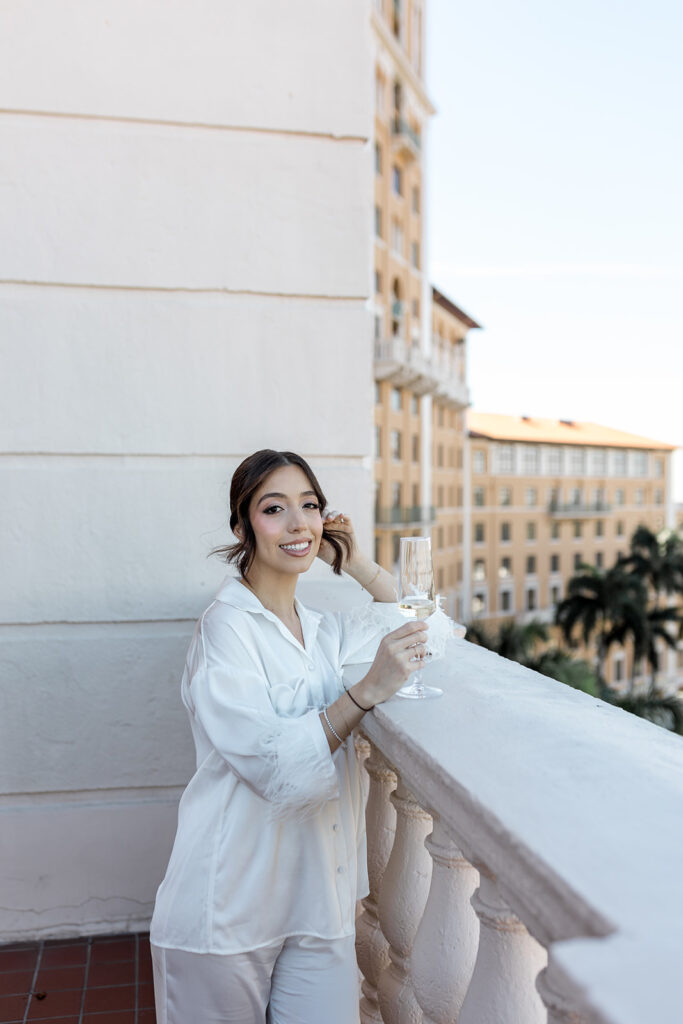 A close-up of Jeannie in her silky bridal pajamas, toasting to her wedding day at Biltmore Hotel Coral Gables.