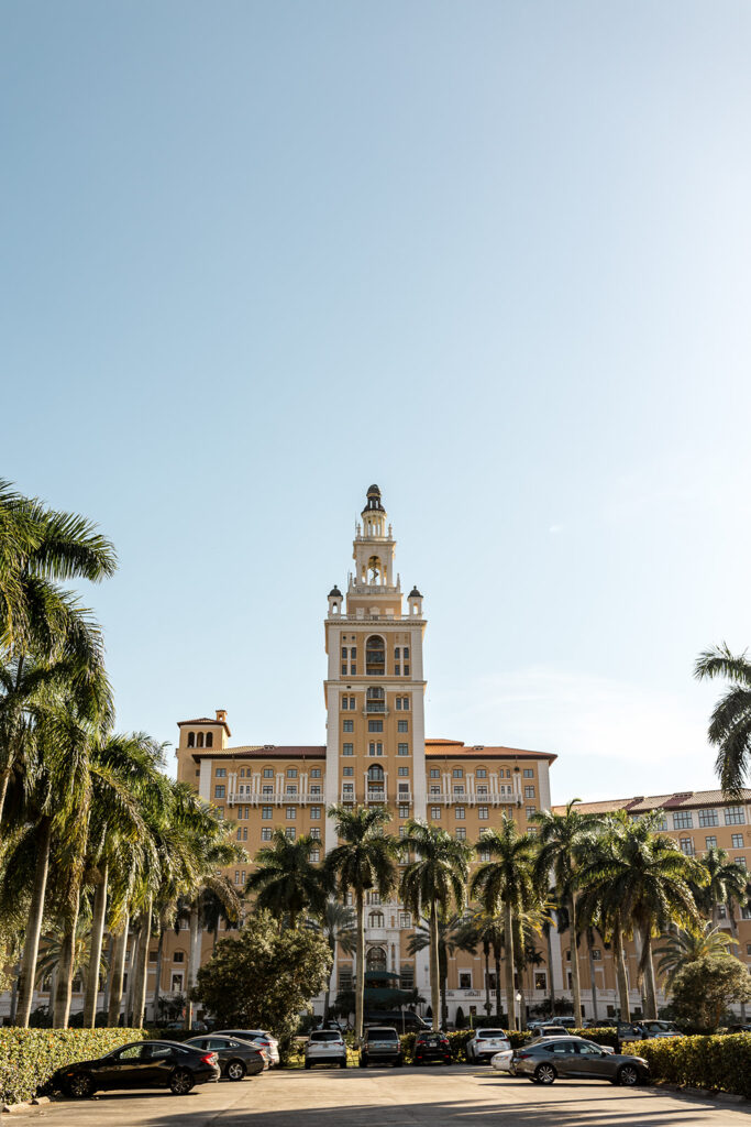 The Biltmore Hotel in Coral Gables, Florida, framed by tall palm trees.