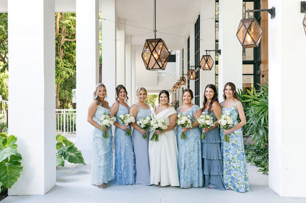 Claire with her beautiful entourage posing at the modern lobby of Baker's Cay resort. Scene captured by Claudia Amalia, a Baker's Cay resort wedding photographer.