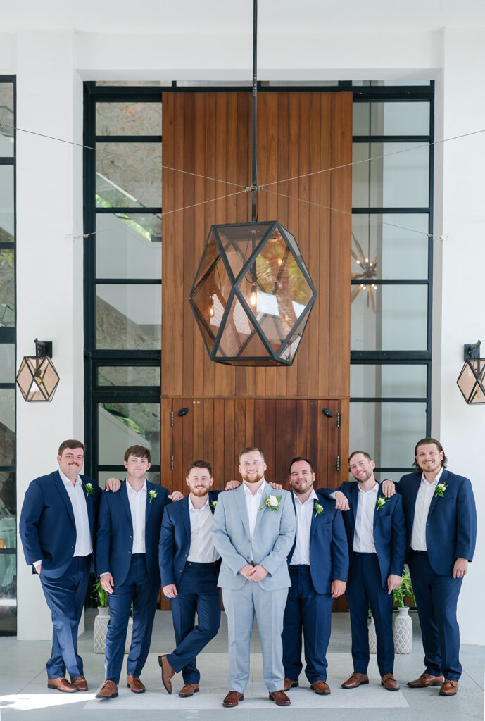 Reece posing with his groomsmen at the lobby of Baker's Cay Resort. Captured by wedding photographer Claudia Amalia.