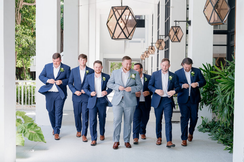 Reece posing with his groomsmen at the lobby of Baker's Cay Resort. Captured by wedding photographer Claudia Amalia.