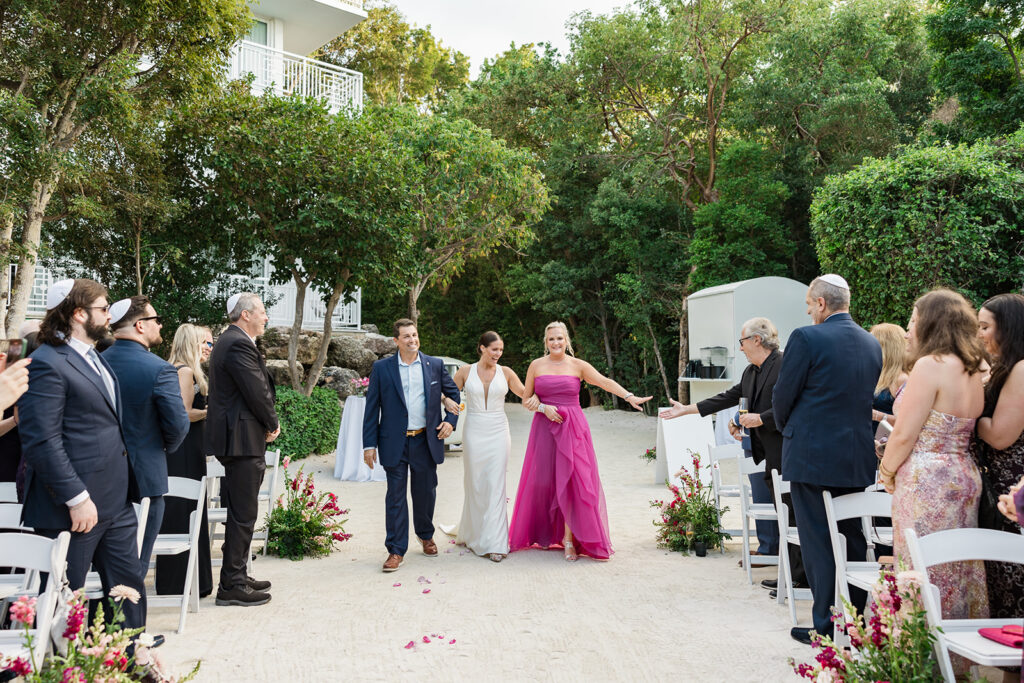 Emotional moment of bride walking down the aisle with her parents for their beautiful Florida Keys weddings ceremony.