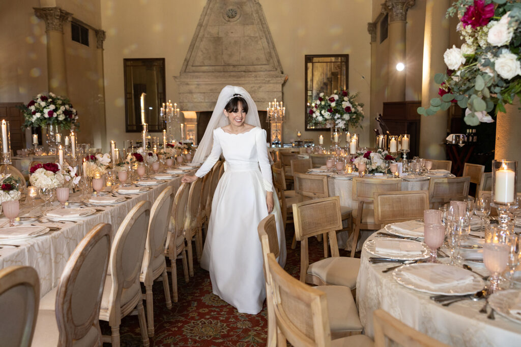 Bride posing by a formal head table setup for a sophisticated Miami weddings reception.
