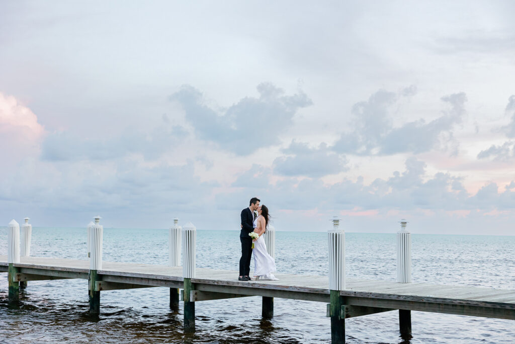 Romantic sunset kiss on a dock for a stunning destination Florida Keys wedding.