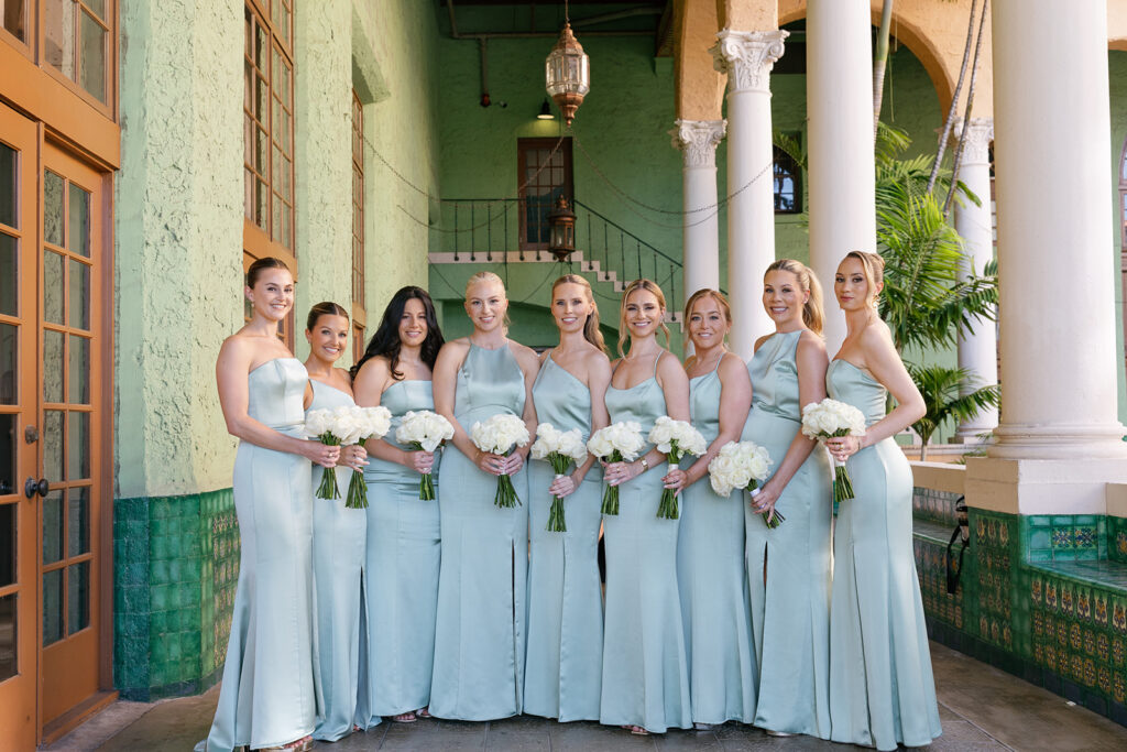 Bridesmaids in light blue dresses at a sophisticated Miami weddings venue with green tile accents.