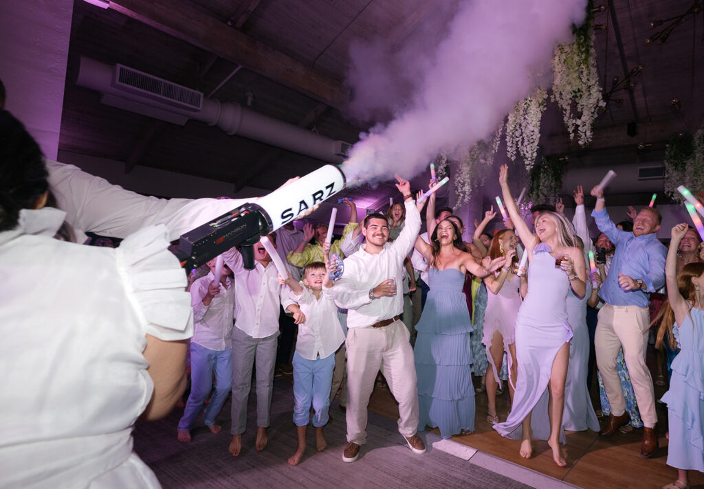Crowd cheering and jumping on the dance floor with a party cannon at a Key Largo weddings party.