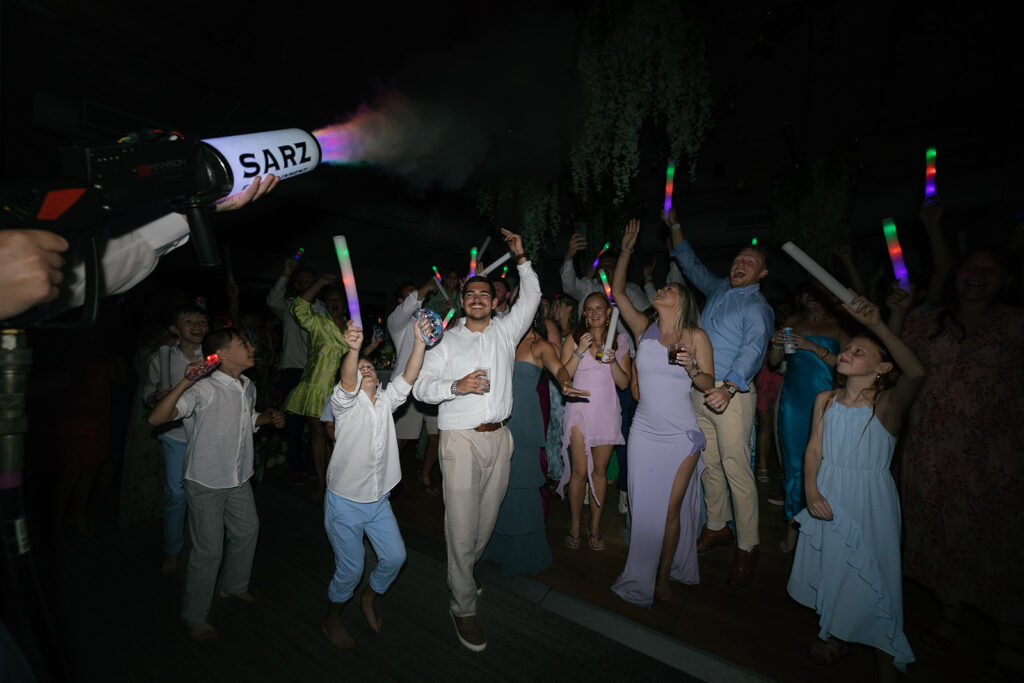 Guests cheering on the dance floor with glow sticks and fog effects for a Florida Keys weddings reception party.