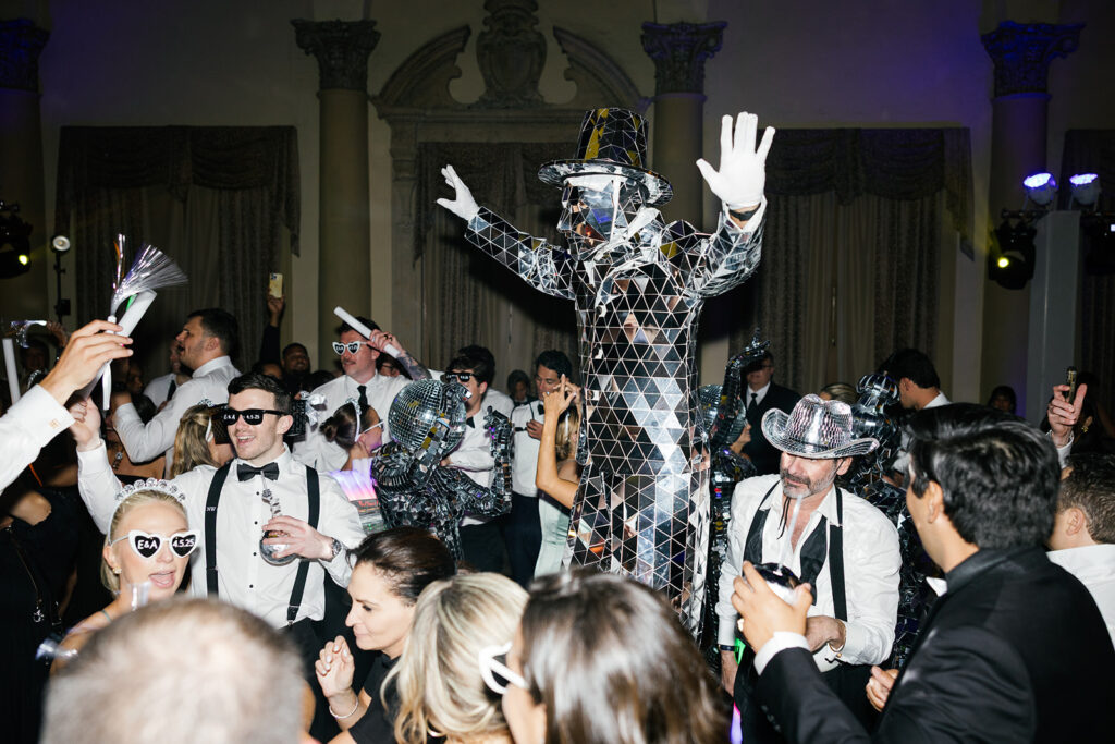 Crowded dance floor with guests and entertainer at an upscale Miami weddings reception.