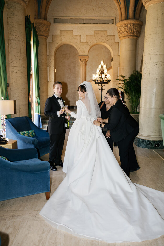 Bride and groom with attendant in an ornate stone-and-archway interior for a city weddings venue.